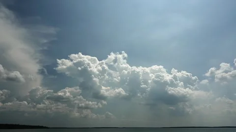 Time lapse of white churning summer clouds with the top sides highlighted  Stock Footage 273347219