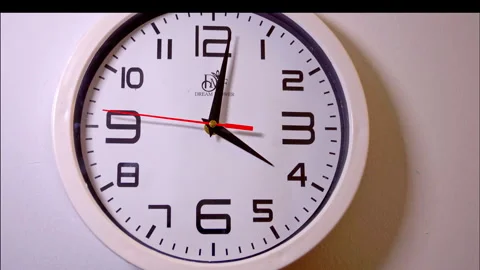 Time-Lapse of a White Circular Wall Clock with a Red Second Hand Stock Footage 337898037