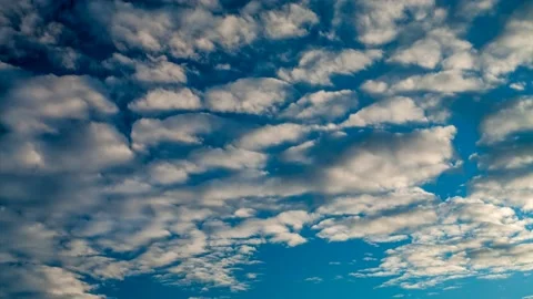 Time lapse.  White clouds against a blue sky, in the light of the setting sun. Stock Footage 166053544