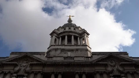 Time lapse of white clouds in a blue sky passing over the Old Bailey Video stock 119441330
