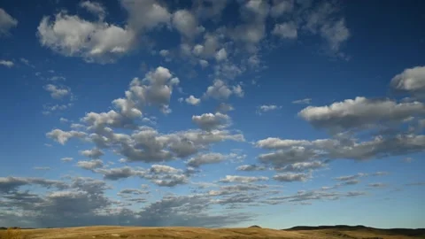 Time lapse of white clouds in a blue sky moving towards the viewer  Stock Footage 289547699