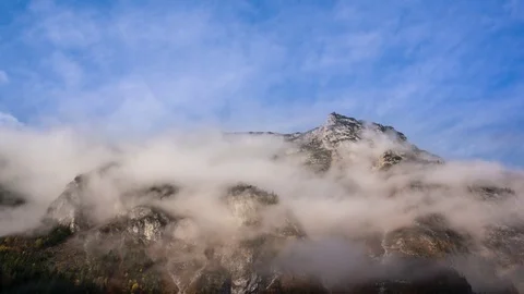 Time lapse of white clouds floating over the rocky mountain Stock Footage 77814537
