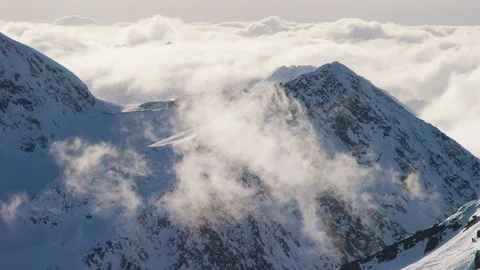 Time-lapse of white clouds floating over the beautiful snow covered mountains Stock Footage 113254690