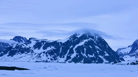 Time-lapse of white clouds floating over a rocky mountain in winter Stock Footage 113268720