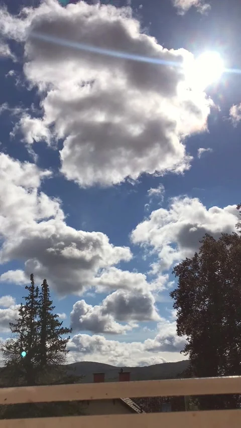 Time lapse, white clouds floating rapidly across the blue sky, the sun shining t Stock Footage 211429272