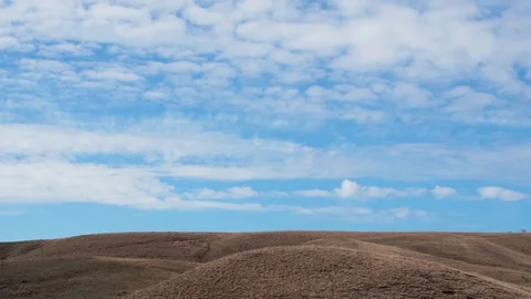 Time lapse white clouds fly over blue sky over hills Stock-Footage 106212514