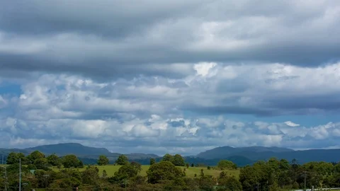Time-lapse of white clouds moving over green rolling landscape Stock Footage 94880705