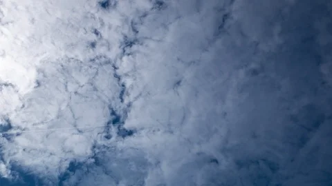 Time lapse of white clouds moving across blue sky with sunlight on left. Stock Footage 104410868