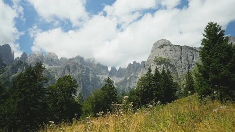 Time-lapse of white clouds moving over the rocky mountains and grassland Stock Footage 109294190