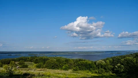 Time lapse of white clouds moving over summer green river valley. Beautiful n Stock Footage 112791577