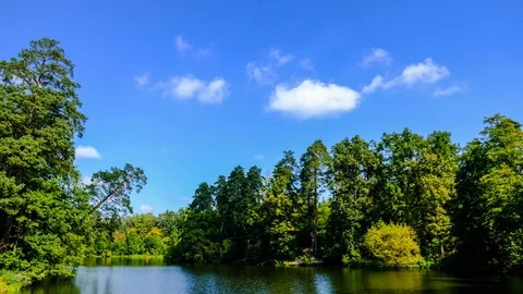 Time lapse of white clouds moving over summer green river valley. Beautiful n Stock Footage 116600609