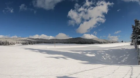 Time-lapse of  white clouds moving over a snowy mountain landscape. Stock Footage 119501424