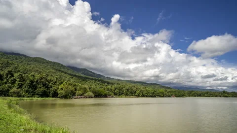 Time lapse of white clouds moving over the mountains and lake Stock Footage 218452938