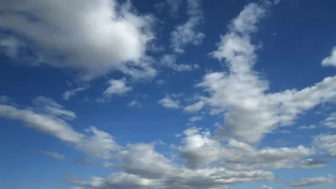 Time lapse of white clouds moving through a bright blue sky.  Stock Footage 251055024