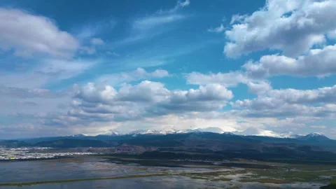 Time-lapse of White Clouds Moving Over Snowy Mountains Video stock 332757363
