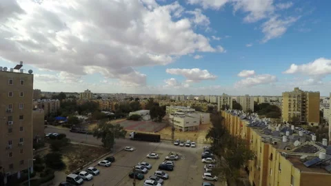 Time-lapse of white clouds over a simple city neighborhood Stock Footage 97734154