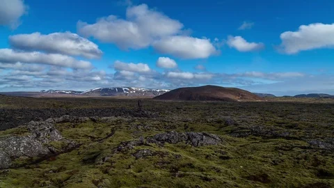 Time lapse of white clouds rolling over the moss field and mountains Stock Footage 73011335
