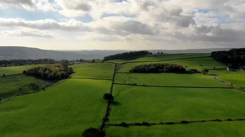 Time-lapse of white clouds rolling over the green fields Stock-Footage 102188343