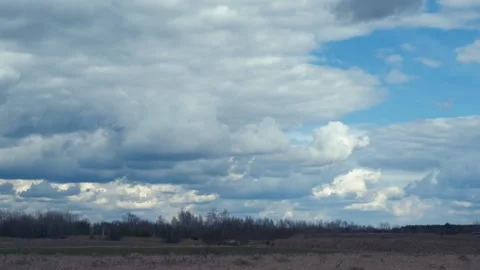 Time lapse with white cumulus clouds over a green field in countryside in autumn Stock Footage 238034524