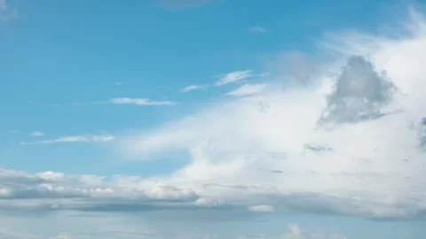 Time lapse of white cumulus clouds moving fast across a bright blue sky Stock Footage 310724728