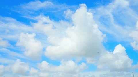 Time lapse of white cumulus clouds moving across a bright blue sky Stock Footage 332727727