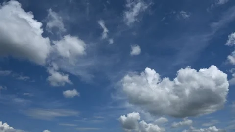 Time lapse of white cumulus clouds building and drifting through a bright blue Stock Footage 336287394
