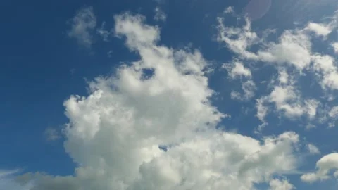 Time Lapse of White fluffy and billowing clouds in a rich blue sky Stock Footage 143681539