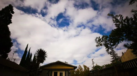 Time lapse of white fluffy clouds over a house Stock Footage 724418