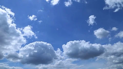 Time lapse of white fluffy clouds over blue sky Stock Footage 77999859
