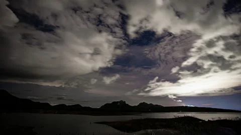 Time-lapse of white fluffy clouds in the night sky Stock Footage 133933899