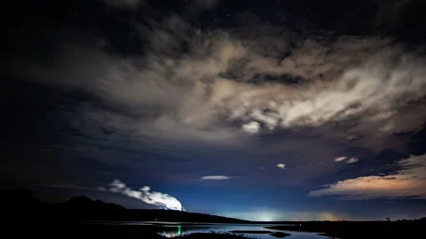 Time-lapse of white fluffy clouds in the night sky Stock Footage 133938636