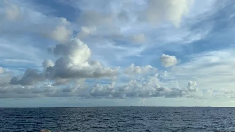 Time Lapse of white fluffy clouds flying over the sea. Stock Footage