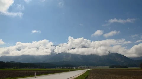 Time lapse of white fluffy clouds moving above the mountains Stock Footage 192495367