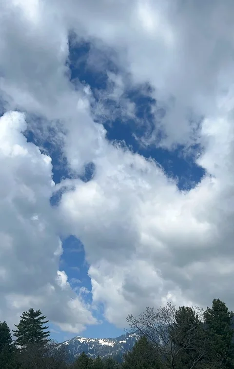 Time-lapse of white fluffy clouds moving across bright blue sky Stock Footage 329322242