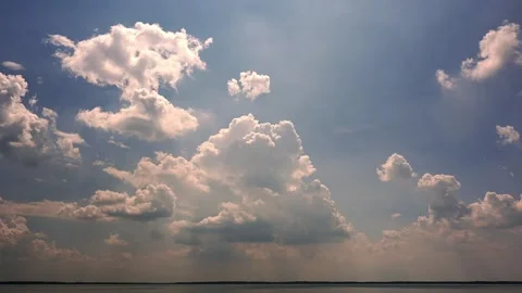 Time lapse of white fluffy cumulus summer clouds building &amp;drifting above a lake Stock Footage 285421484