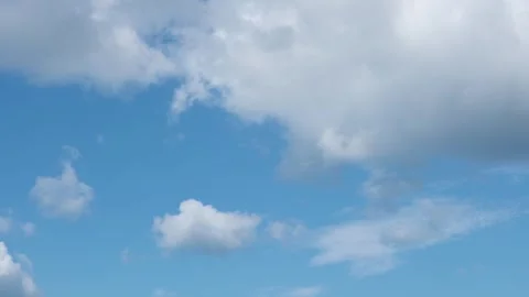 Time lapse of white fluffy disappearing clouds moving in the blue sky.  Stock Footage 281648960