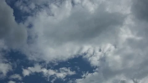 Time lapse of white to medium gray puffy clouds moving through a blue sky Stock Footage 242801425