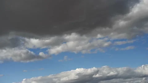 Time lapse of white midday clouds moving diagonally through a blue sky Stock Footage 219636566