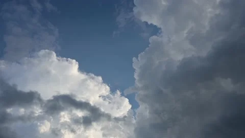 Time lapse of white puffy cloud becoming hidden by large blue-grey cloud. Stock Footage 206458381