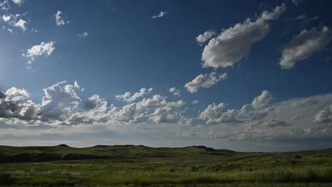 Time lapse of white summer clouds moving above a prairie badlands setting  Stock Footage 280357235