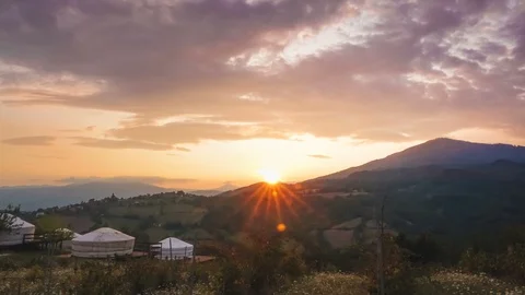 Time lapse of Wild Landscape at Sunset with Yurts on a Hill Stock Footage 123220120