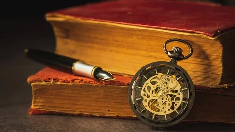 Time lapse winding pocket watch placed beside the old book and the pen. Stock Footage 104480049