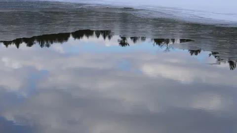 Time Lapse Winter Clouds And Blue Sky And Trees On Unfrozen Water Edge Of Ice Stock Footage 162202000