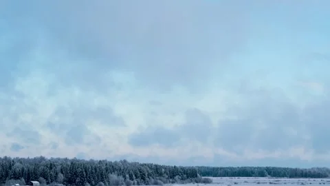 Time lapse of a winter landscape with moving clouds over a snow-covered forest Stock Footage 293484854