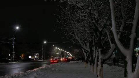 Time lapse of the winter night road in the city. Dirty roadside snow. Stock Footage 83077999