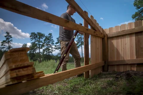 Time-Lapse of Worker Building Cedar Fence with Mountains in Background Stock Footage 315921616