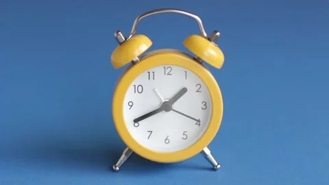 Time-lapse yellow alarm clock on blue background close-up. Stock Footage 145681743