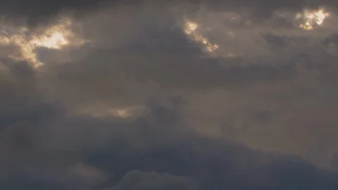 Time lapse of yellow and dark bluish-gray clouds with sunlight peaking through Video stock 106268502