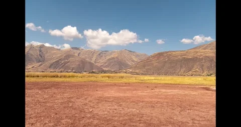 Time lapse of yellow grass with distant mountains and clouds Stock Footage 293093599