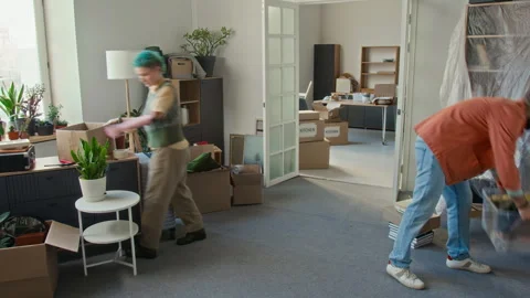 Time Lapse of Young Couple Bringing Boxes into Spacious Room after Moving In Video stock 323302146